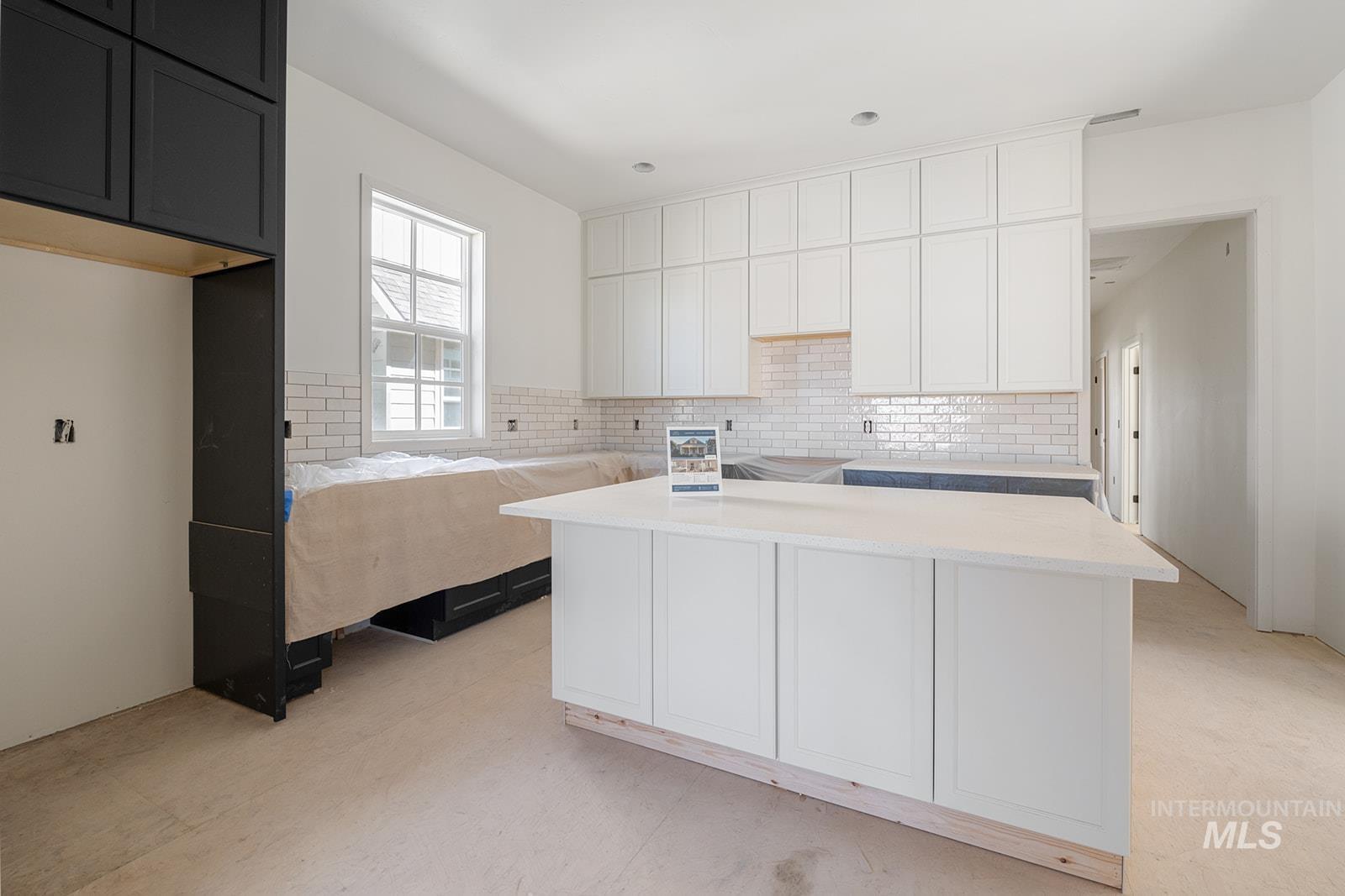 1452 Picotee Circle, Unit ROSE Moscow, ID 83843 - Photo 7 of 19 Kitchen with decorative backsplash, white cabinetry, a center island, light countertops, and dark cabinetry