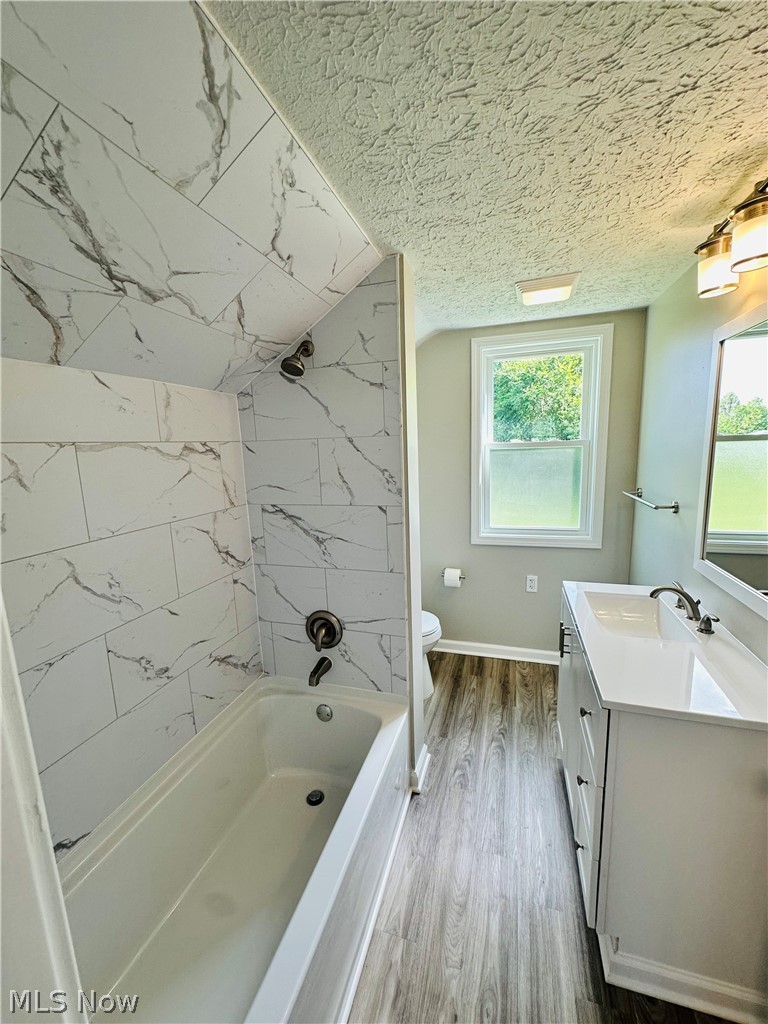 1003 Ravenna Road Kent, OH 44240 - Photo 8 of 16 Full bathroom featuring oversized vanity, wood-type flooring, tiled shower / bath, a textured ceiling, and toilet
