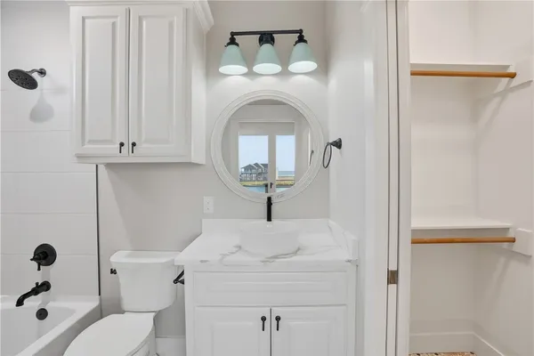 a bathroom with a toilet a sink and mirror