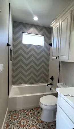 a utility room with a sink a toilet and mirror