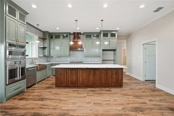 a kitchen with stainless steel appliances granite countertop a stove a sink and a refrigerator