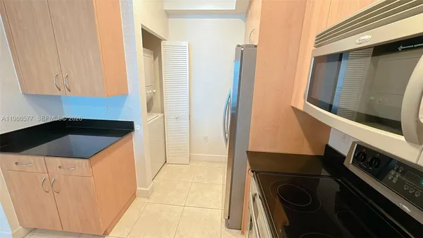 a view of a kitchen with a fridge and wooden floor
