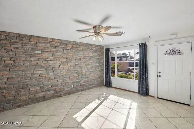 a view of a livingroom with a ceiling fan and window
