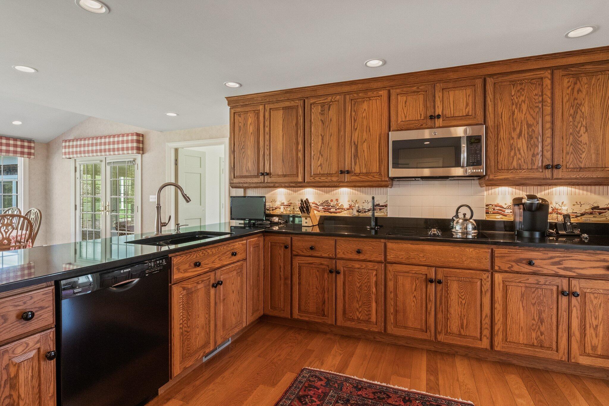 137 Strong Island Road Chatham, MA 02633 - Photo 11 of 37 a kitchen with granite countertop wooden cabinets stainless steel appliances a sink and a window