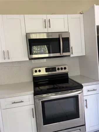 a stove top oven sitting inside of a kitchen