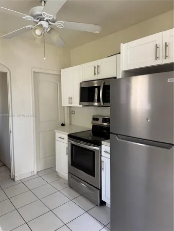 a white refrigerator freezer and a stove sitting inside of a kitchen