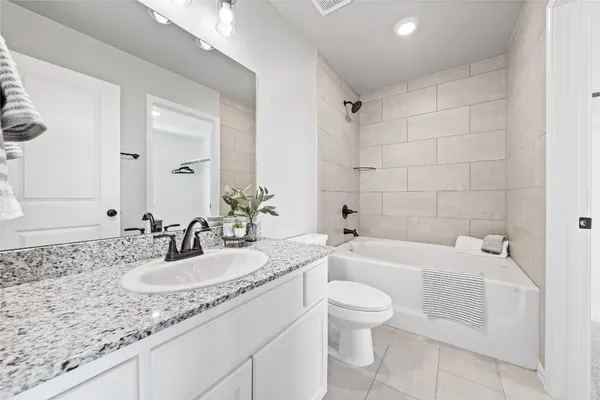 a bathroom with a granite countertop sink a toilet and bathtub