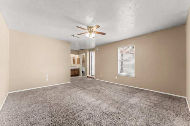 an empty room with closet and a ceiling fan