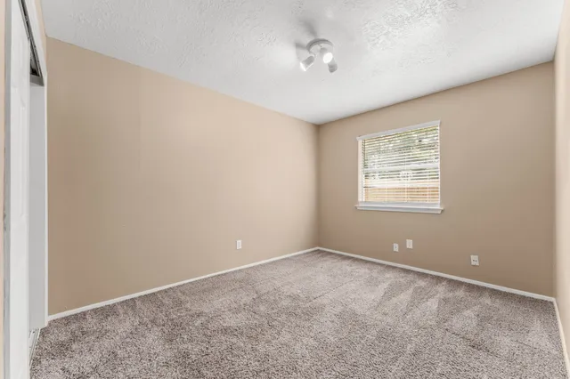 an empty room with closet and a ceiling fan