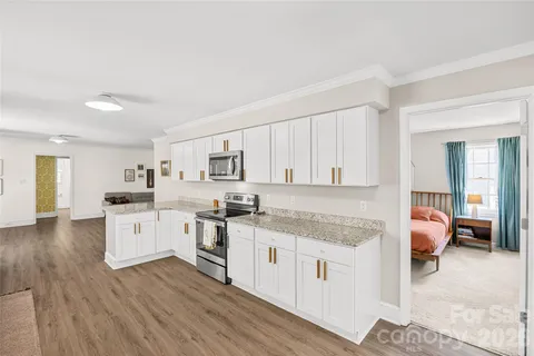 a kitchen with granite countertop white cabinets and white appliances