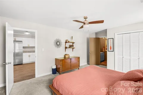 a bedroom with a bed and a refrigerator