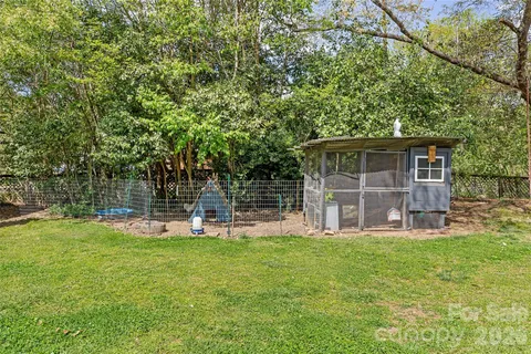 a view of a chair and table in backyard of house