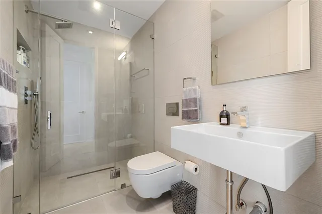 a bathroom with a sink a toilet and shower