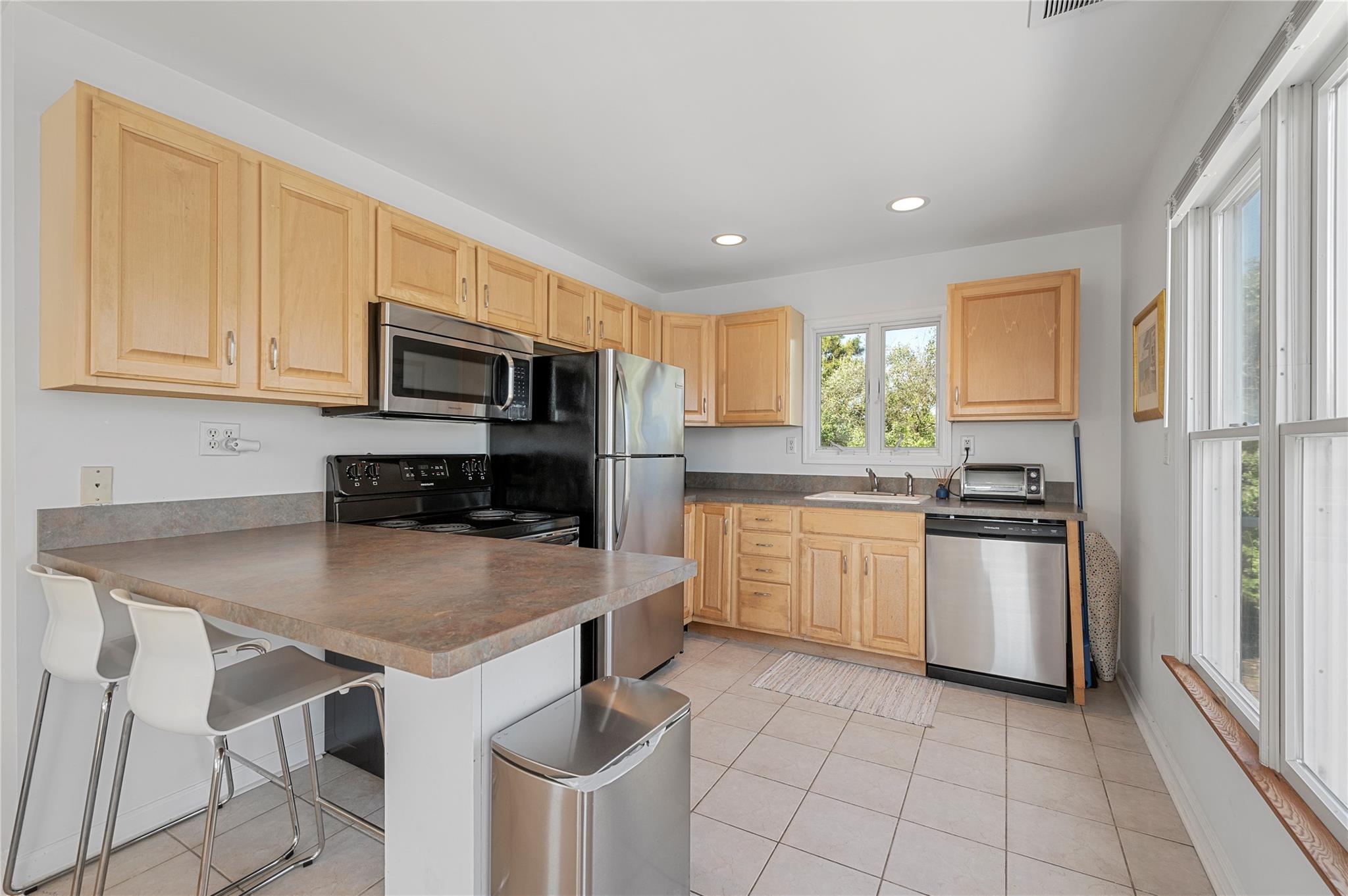 846 Dune Road West Hampton Dunes, NY 11978 - Photo 33 of 49 a kitchen with kitchen island granite countertop stainless steel appliances a stove sink microwave and refrigerator