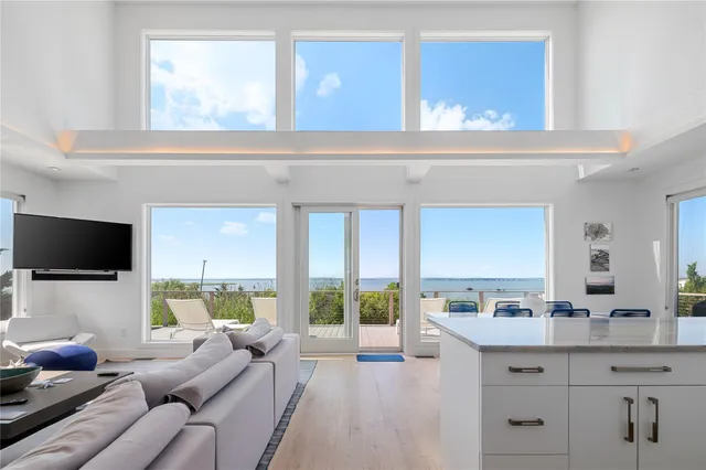 a living room with furniture a large window and a flat screen tv
