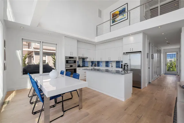 a kitchen with a dining table chairs and refrigerator