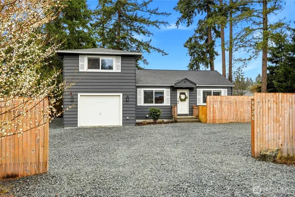 a view of a house with a yard and wooden fence