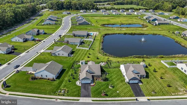 an aerial view of a tennis ground and a cars park side of the road