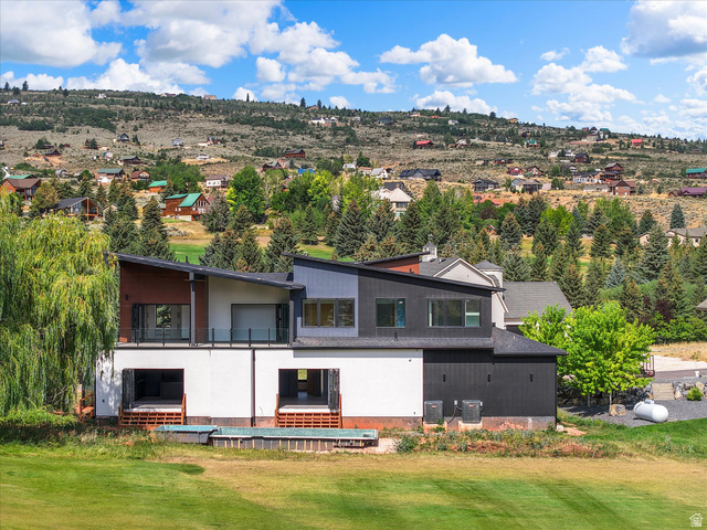 2610 Foxridge Road Garden City, UT 84028 - Photo 2 of 71 Modern architectural design featuring multi-level construction, multiple balconies with glass railings, an integrated plunge pool, and expansive green space