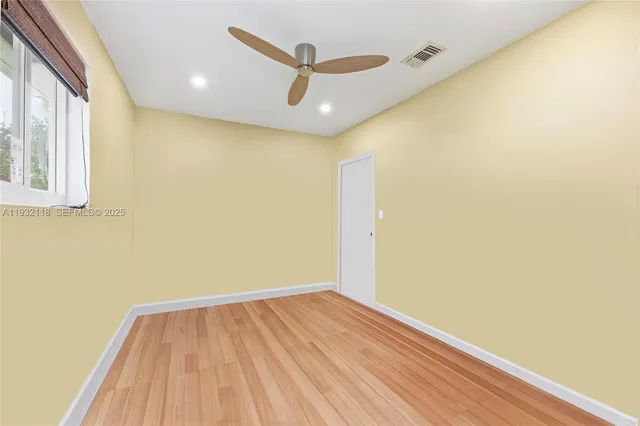 a living room with a black white checkered floor with a gaming machine and dining chairs