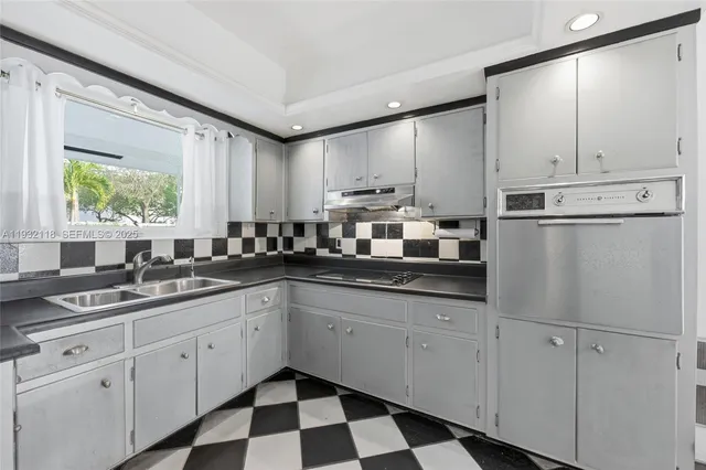 a kitchen with granite countertop white cabinets white appliances and sink