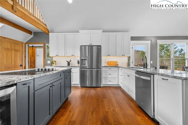 a kitchen with stainless steel appliances granite countertop a stove a sink and a refrigerator