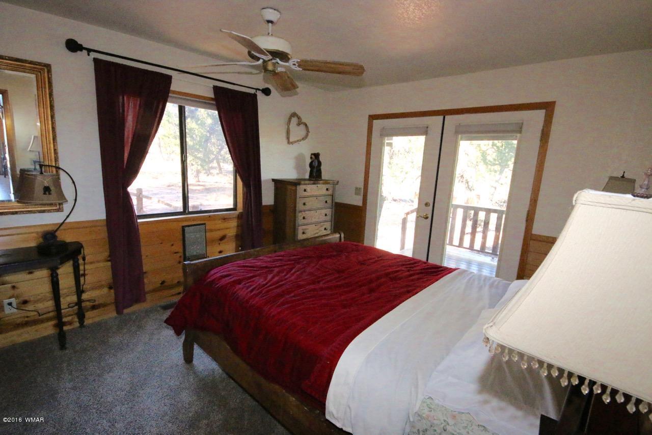 2885 Cedar Ridge Drive Overgaard, AZ 85933 - Photo 19 of 43 a bedroom with a large bed and a window