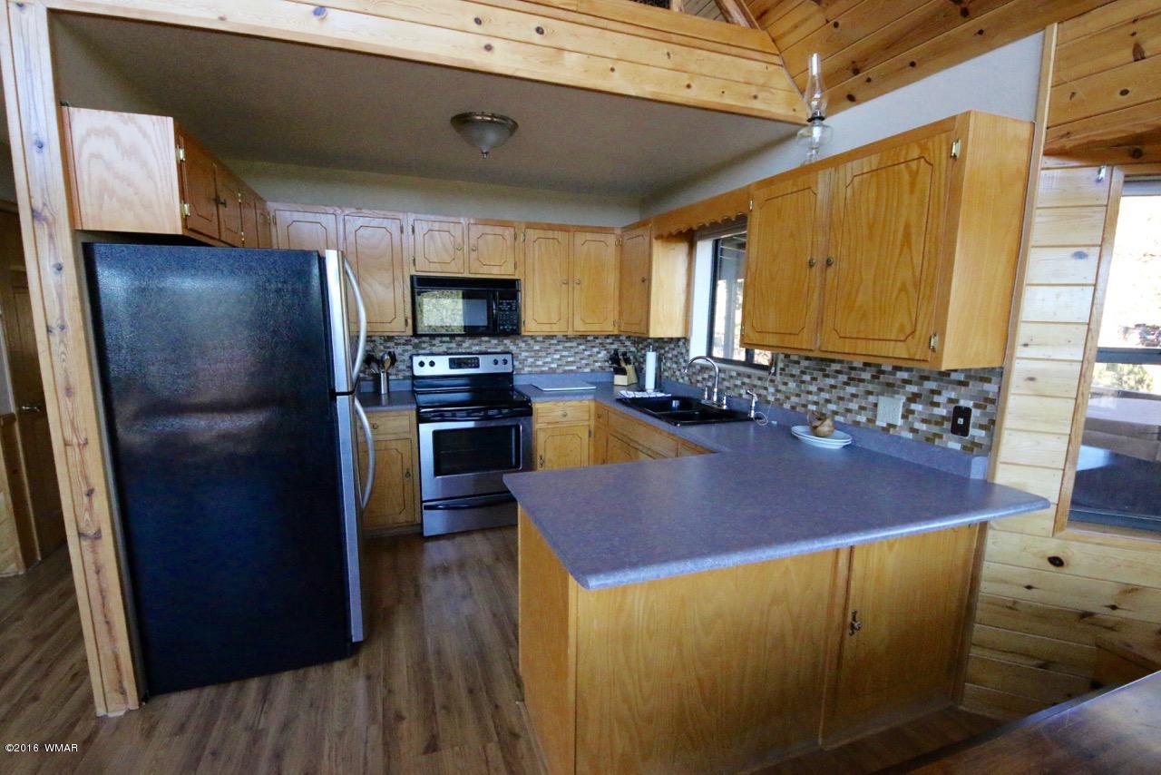2885 Cedar Ridge Drive Overgaard, AZ 85933 - Photo 6 of 43 a kitchen with stainless steel appliances granite countertop a refrigerator and a stove