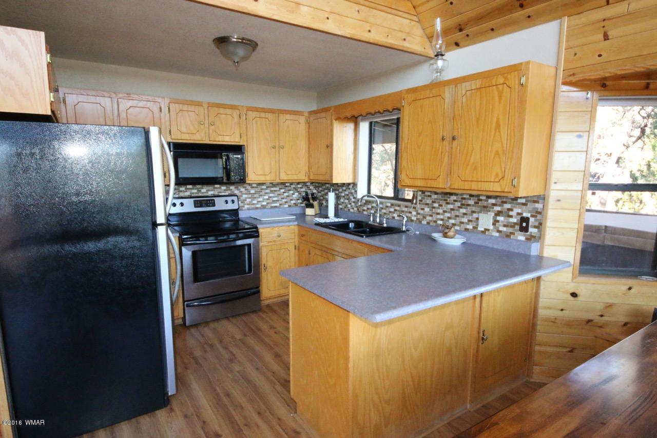 2885 Cedar Ridge Drive Overgaard, AZ 85933 - Photo 8 of 43 a kitchen with stainless steel appliances a stove a sink a microwave a refrigerator and cabinets
