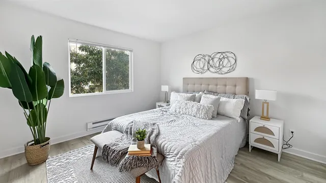 a bedroom with a bed and a potted plant