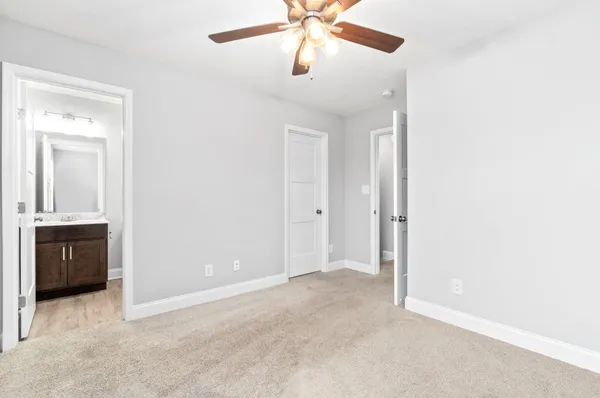 an empty room with closet and a chandelier fan