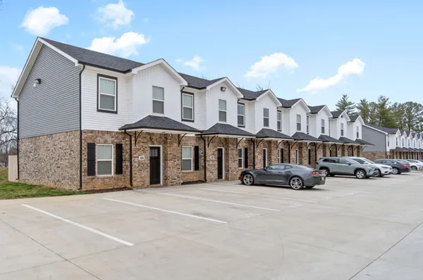 a couple of cars parked in front of a white building
