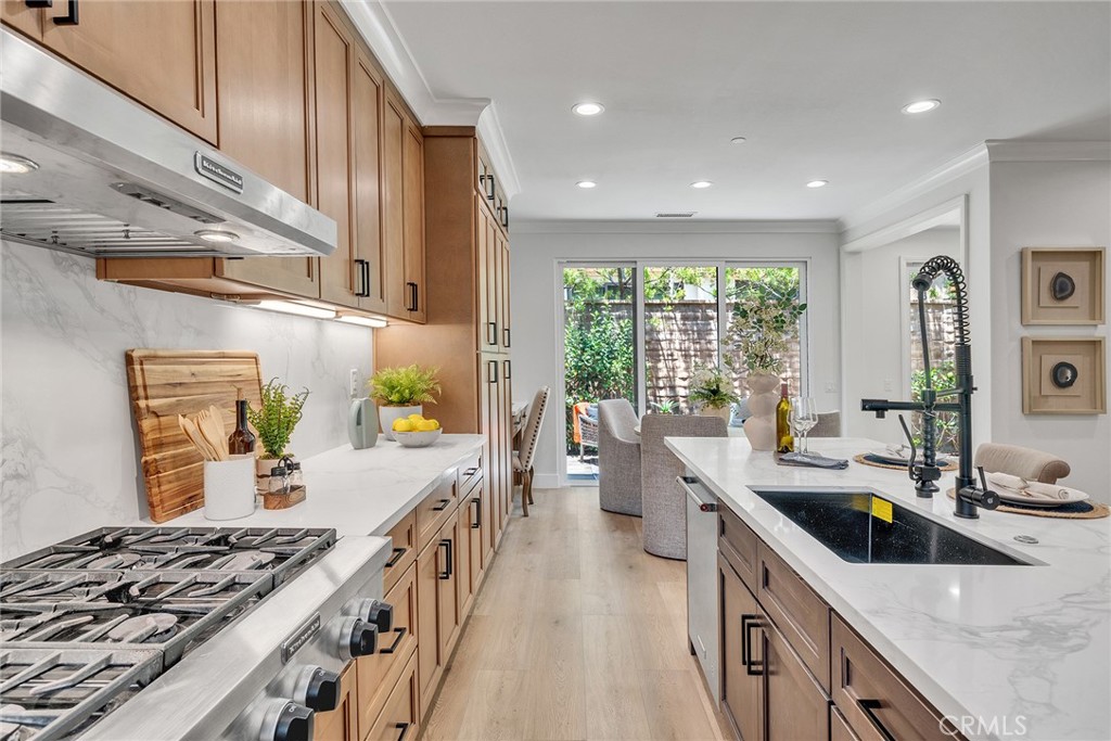 55 Open Range Irvine, CA 92602 - Photo 15 of 66 a kitchen with stainless steel appliances a sink a stove and a wooden floor
