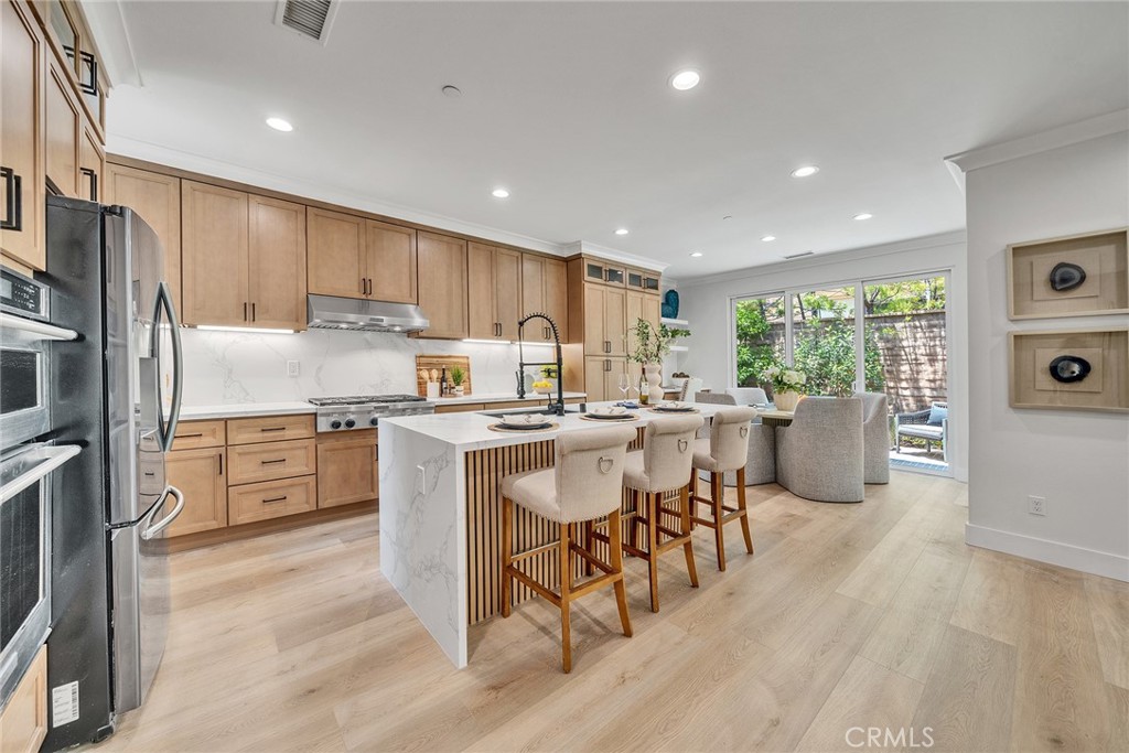 55 Open Range Irvine, CA 92602 - Photo 10 of 66 a kitchen with refrigerator cabinets dining table and chairs