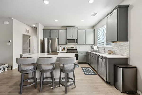 a kitchen with stainless steel appliances kitchen island granite countertop a sink and cabinets