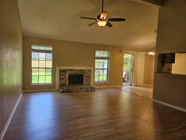 a view of an empty room with a fireplace and a window