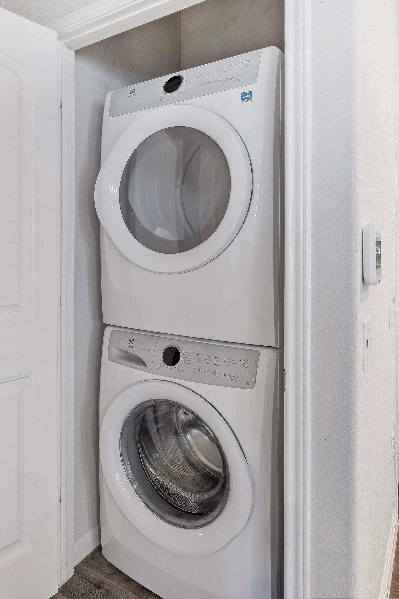 14409 Frankel Loop, Unit 33A Pflugerville, TX 78660 - Photo 22 of 29 Laundry area with stacked washer / drying machine and dark wood-type flooring