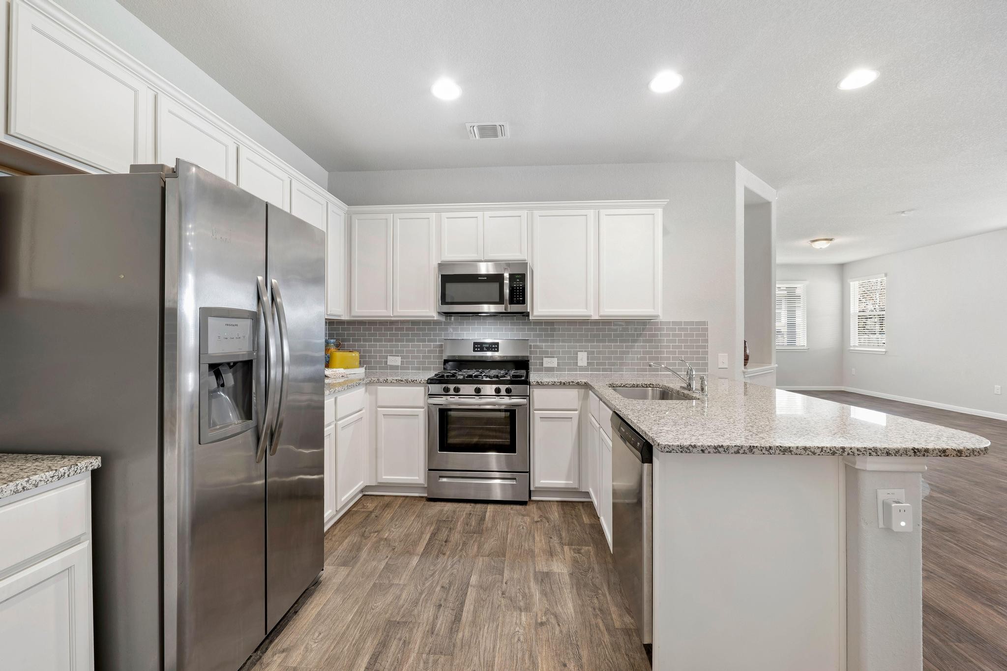 14409 Frankel Loop, Unit 33A Pflugerville, TX 78660 - Photo 10 of 29 Kitchen featuring stainless steel appliances, dark wood finished floors, white cabinetry, and recessed lighting