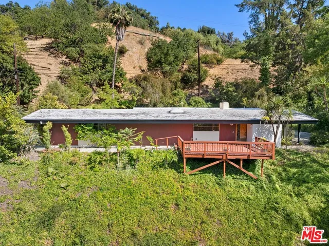 a view of a backyard with a garden and deck