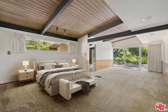 a spacious bedroom with a bed and a large window