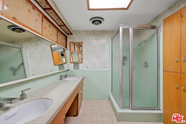 a bathroom with a granite countertop double vanity sink and mirror
