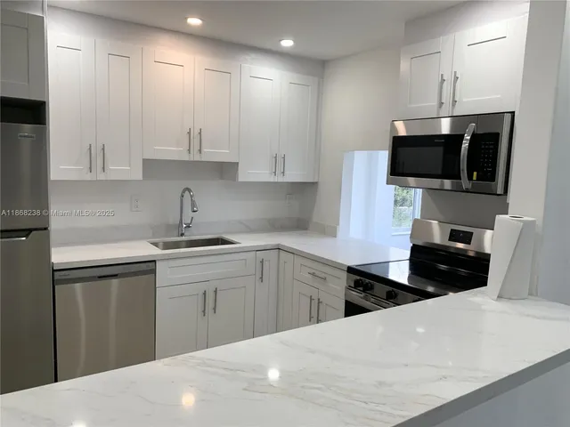 a kitchen with a sink a stove and refrigerator