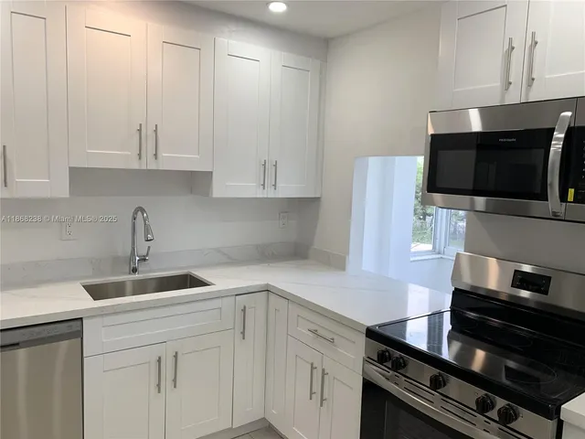 a kitchen with a sink and white cabinets