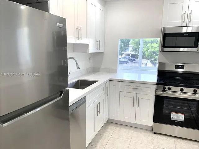 a kitchen with stainless steel appliances a refrigerator a stove a microwave a sink and cabinets