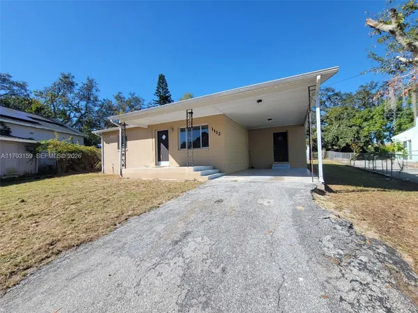 a view of a house with a yard and potted plants