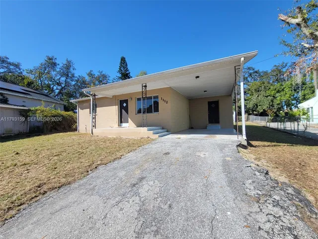 a view of a house with a yard and potted plants