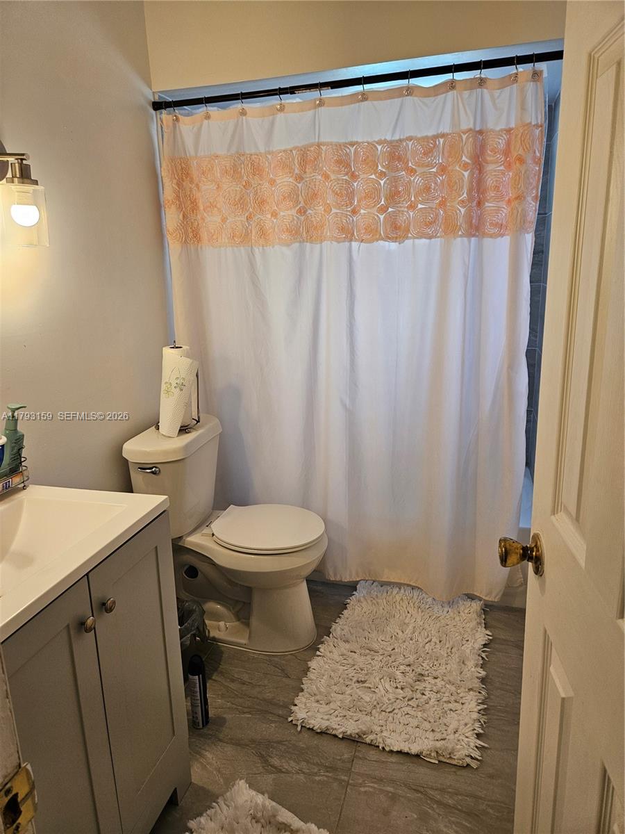 1112 Evanston Street Sebring, FL 33870 - Photo 27 of 41 a bathroom with a sink a toilet and shower curtain