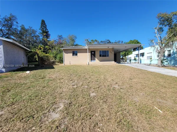 a view of a house with a yard and potted plants