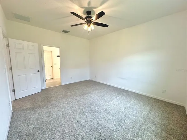 an empty room with a ceiling fan and a window