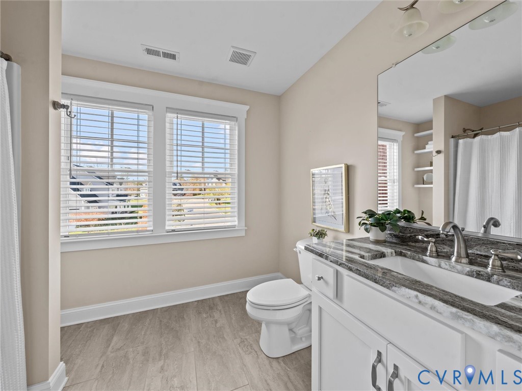 2001 Tulip Hill Drive Midlothian, VA 23112 - Photo 42 of 50 a bathroom with a toilet a sink a mirror and a window